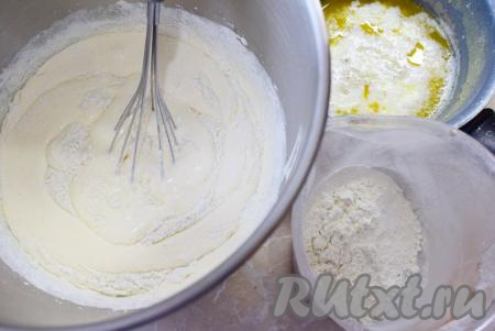 В отдельной ёмкости соедините муку с ванилином и содой, хорошо перемешайте мучную смесь. К взбитым яйцам поочередно частями подмешивайте мучную смесь и тонкой струйкой понемногу добавляйте горячую молочную смесь, каждый раз хорошо перемешивая тесто венчиком. Именно при перемешивании венчиком масса будет оставаться пышной. Миксер на этом этапе использовать не надо. Для того чтобы бисквит получился пышным, добавляйте молочную и мучную смеси приёма в 3-4, каждый раз аккуратно и уверенно вмешивая их в тесто.