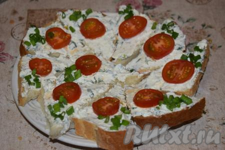 Далее каждый кусочек хлеба смазываем подготовленной творожной намазкой (примерно, по 1 чайной ложке на каждый кусочек хлеба). Нарезаем зелёный лук мелко, а помидорчики черри - на кружочки. Посыпаем&nbsp;луком&nbsp;каждый бутерброд и выкладываем по кружочку помидора.