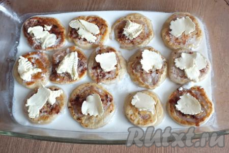 Получившимся сметанным соусом залейте ленивые пельмени. Соус не должен полностью покрывать их. Сверху, на каждый ленивый пельмешек, положите по кусочку сливочного масла. Накройте форму с ленивыми пельменями в&nbsp;сметанном соусе фольгой и поставьте в разогретую до 180 градусов духовку на 20-25 минут.&nbsp;