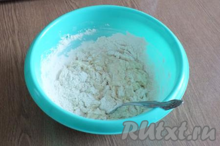 Всыпьте второй стакан муки. Перемешивайте вилкой, пока тесто не соберётся в комочки. Затем, постепенно подсыпая муку, замешивайте тесто.