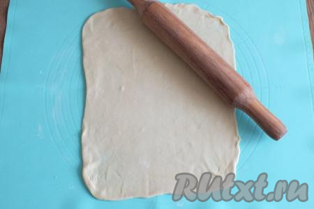 Подпылите стол 0,5 столовой ложки муки. Раскатайте одну часть теста в прямоугольник размером, примерно, 24 см на 36 см. Чем тоньше у вас получится пласт, тем лучше, но не увлекайтесь. Важно, чтобы на тесте не было разрывов!