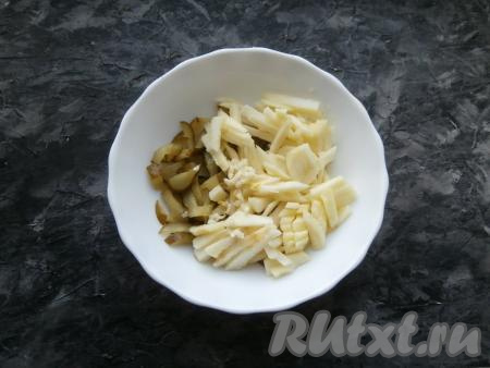 К солёным огурцам добавить чеснок, пропущенный через пресс, и нарезанное яблоко, предварительно очищенное от кожуры и семян, а затем политое лимонным соком.