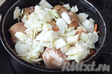 К обжаренной курице добавьте капусту, перемешайте, обжарьте в течение 5 минут, после влейте 100 мл воды, дайте закипеть. Накройте сковороду крышкой, сделайте огонь чуть ниже среднего и тушите 15-20 минут.