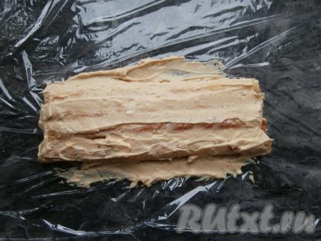 Из 14 испеченных слоёных полос&nbsp;отложить 2 штуки для украшения. Остальные выкладывать на лист пищевой плёнки по 3 штуки в 4 слоя, обильно смазывая кремом, - так мы как бы формируем наше полено.