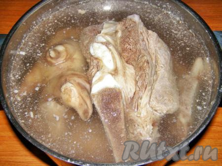 По прошествии времени сливаем воду в раковину, говядину и ножки промываем тёплой водой. Кладём в чистую кастрюлю говядину со свиными ногами, заливаем, примерно, 4 литрами чистой воды (из расчёта 2 литра воды на 1 кг мясных продуктов) и на сильном огне доводим до кипения. Когда вода закипит, уменьшаем огонь до минимального, накрываем кастрюлю крышкой и оставляем вариться на 5-6 часов. Вода может немного испаряться из кастрюли, но доливать воду ни в коем случае нельзя, иначе холодец не застынет.