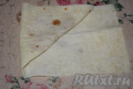 Затем получившийся треугольник берём за острый верхний край и сворачиваем так, чтобы этот край оставался вверху.