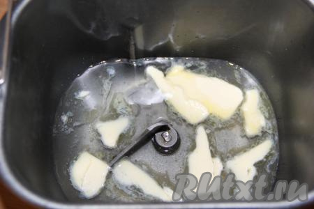 В ведёрко хлебопечки влить воду комнатной температуры и добавить кусочки мягкого сливочного масла. Всыпать соль и сахар.