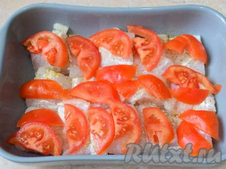 Помидоры вымойте, удалите плодоножку и нарежьте их тонкими ломтиками. Выложите нарезанные помидоры по всей поверхности филе судака в сливках.