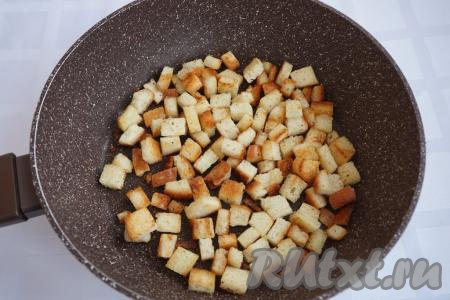 В это время приготовим сухарики, они особенно порадуют деток. Для приготовления сухариков нарежем 200 граммов батона на мелкие кубики, нальём в сковороду 30 мл растительного масла, приправим солью и специями, обжарим, периодически помешивая, до золотистого цвета на среднем огне.