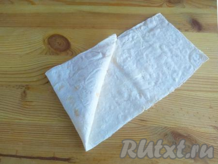 Затем, взяв верхний край треугольника, повернуть треугольник с начинкой так,&nbsp;чтобы он оказался на листе лаваша (как на фото).&nbsp;Продолжить сворачивать лаваш с начинкой в виде треугольника так, чтобы смазанная маслом&nbsp;сторона лаваша была внутри, формируя треугольную самсу с начинкой внутри.