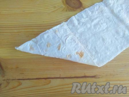 Завернуть начинку по диагонали, начиная с нижнего края, чтобы получился подвёрнутый треугольник.