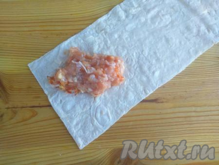 Теперь нужно будет завернуть мясной фарш в полоску лаваша в виде треугольного конверта так, чтобы начинка была запечатана внутри лаваша. Первым делом&nbsp;на край лаваша выложить 1,5 столовые ложки фарша.