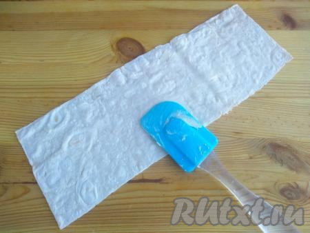 Подготовленные полоски лаваша выложить на твёрдую поверхность, смазать с помощью силиконовой лопатки размягчённым сливочным маслом. 