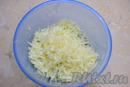 Переложите капусту в достаточно объёмную чашу. Капусту немного помните руками. От этого она станет немного мягче, быстрее пустит сок и готовый салат получится более сочным.