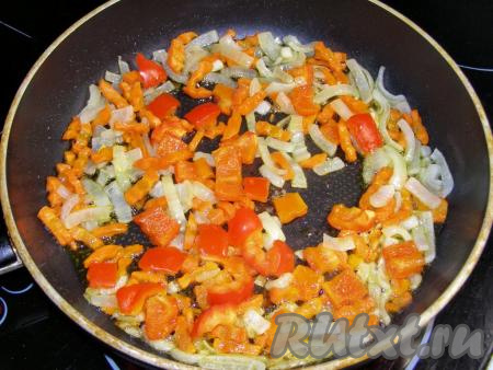 Затем к морковке с луком выкладываем кубики болгарского перца, перемешиваем и обжариваем ещё 3-4 минуты, не забывая помешивать время от времени.