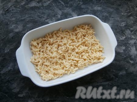 Подмёрзшее тесто разделить на 2 части. В форму для запекания (у меня размер - 22 см х 15 см) натереть на крупной тёрке одну часть теста, разровнять.