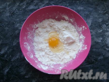 Перетереть получившуюся смесь руками в крошку, затем добавить одно сырое яйцо и сметану.