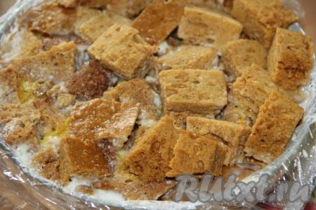 Таким образом собрать торт. Последний слой должен быть из кусочков бисквита, прижать этот слой, закрыть свисающими краями плёнки. Поставить торт в холодильник на ночь.