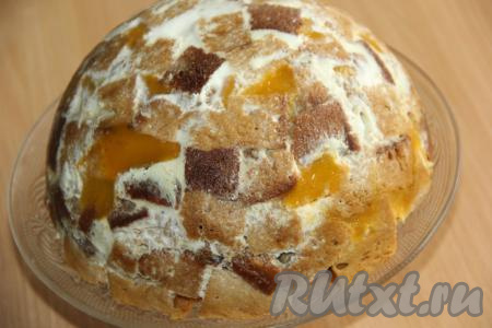 Готовый медовый торт, приготовленный со сметанным кремом и фруктами, перевернуть на плоскую тарелку и убрать пищевую плёнку.