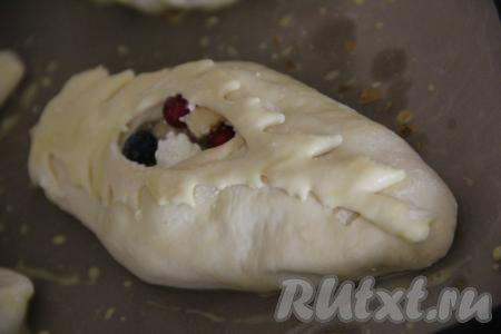 Переложить пирожки с яблоками и творогом на противень, застеленный пергаментом (или силиконовым ковриком) и оставить на 20 минут. Затем тесто пирожков смазать взбитым яичным желтком.