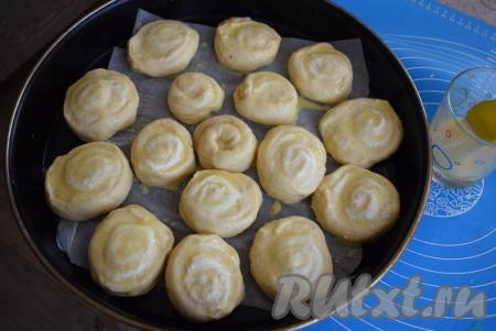 Булочки смазываем взбитым яйцом&nbsp;при помощи кулинарной кисти. Накрываем форму с булочками плёнкой и ставим на расстойку на 35-40 минут.