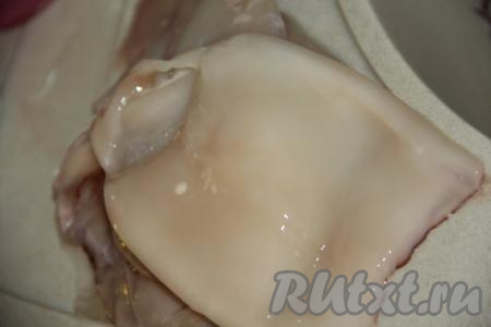 Разморозить при комнатной температуре кальмаров, а затем очистить их от плёночки, находящейся на поверхности тушки, удалить хорду, расположенную внутри кальмара. Промыть под проточной водой.