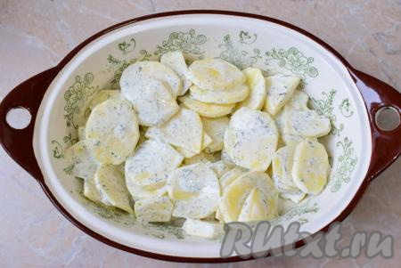 Для запекания блюда возьмите любую жаропрочную форму. Смажьте дно и бока формы растительным маслом и выложите картофель в сметане. Равномерно распределите его по всей форме.