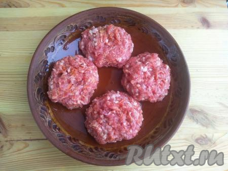 Из фарша сформировать четыре круглые котлеты и немного приплюснуть их сверху. Форму для запекания смазать растительным маслом, выложить котлетки в форму.