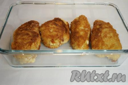 В результате обжаривания у нас получатся аппетитные конвертики из куриного филе с начинкой из ветчины и сыра. Далее перекладываем эти конвертики в форму для запекания и отправляем в предварительно разогретую до 180 градусов духовку, буквально, на 10 минут. Это позволит довести блюдо до готовности. Помните, форму нельзя накрывать крышкой, иначе хрустящая корочка не получится.