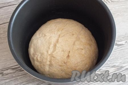 Чашу мультиварки смажьте растительным маслом и выдержите на режиме "Подогрев" в течение 2 минут. Выложите в чашу округлённое тесто, сделайте неглубокие разрезы. Закройте крышку и выдержите 15 минут. После, не открывая крышку, включите режим "Выпечка" на 45 минут.