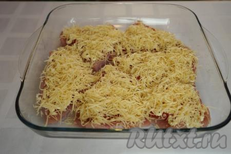 Наши отбивные из индейки с помидорами щедро присыпаем натёртым сыром и отправляем в разогретую до 180 градусов духовку на 20-25 минут.