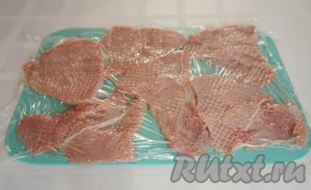 Теперь необходимо отбить мясо. Чтобы не пачкать всё вокруг, я застилаю филе пищевой плёнкой и отбиваю через неё - так получается гораздо аккуратнее.