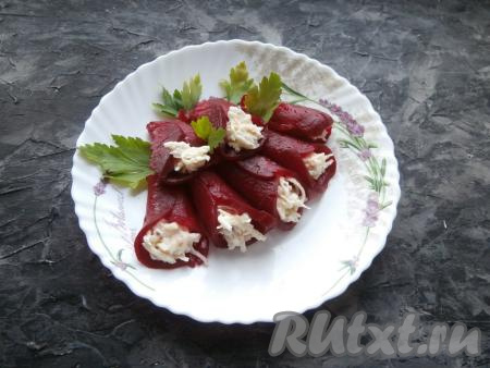 Выложить все "кулёчки" из свеклы и сыра на тарелку, украсить закуску зеленью.