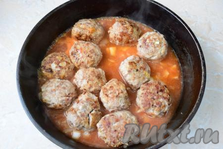 Залейте томатным соусом мясные шарики. Доведите соус до кипения. Накройте сковороду крышкой и тушите на небольшом огне 20-25 минут. За это время рис станет мягким. Во время тушения переверните ёжиков пару раз, чтобы они готовились более равномерно.
