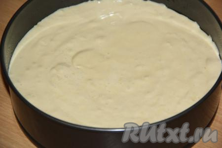 Для выпечки ванильного бисквита взять разъёмную форму диаметром 28 сантиметров, застелить её дно пергаментом и смазать бока формы растительным маслом. Выложить бисквитное тесто и разровнять.