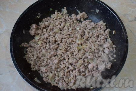 К обжаренному луку добавьте мясной фарш, перемешайте и обжаривайте, иногда перемешивая и разбивая комочки мяса, минут 7-8. В процессе обжаривания к фаршу с луком добавьте специи и соль.