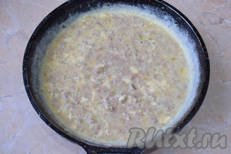 Когда фарш обжарится в течение 7-8 минут, залейте его молочно-яичной смесью, перемешайте. Накройте сковороду крышкой и готовьте омлет на минимальном огне 5-7 минут (верх омлета должен стать достаточно сухим).