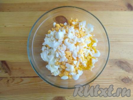 Яйца выложить в кастрюлю с холодной водой, варить на медленном огне в течение 7-8 минут с момента закипания. Затем охладить яйца, залив их холодной водой, а после этого очистить от скорлупы и нарезать мелко. Добавить нарезанные яйца в салат.