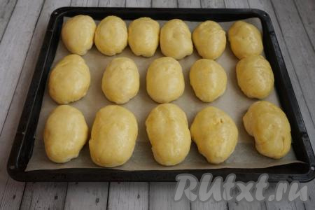 Далее нужно дать подняться пирожкам. Оставляем противень в тепле ещё на 15-20 минут. Если у вашей духовки есть возможность задать температуру на уровне 30 градусов, то можно поставить в духовку. Тогда достаточно будет 7-10 минут. По прошествии времени достаём из холодильника желток, добавляем к нему 1 столовую ложку воды, перемешиваем и смазываем верх подошедших пирожков - это позволит получить яркий и красивый румянец у выпечки.