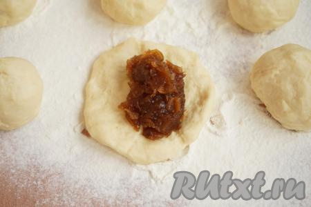 Начинаем формировать пирожки. Для этого руками превращаем каждый шарик в лепёшку, на середину выкладываем начинку. Я выкладывала по чайной ложке с горкой яблочного повидла на каждую лепёшку - при таком количестве повидла и начинки достаточно, и пирожки не лопаются. Обратите особое внимание на то, что повидло для пирожков должно быть непременно густым. Если начинка жидкая, то в процессе выпечки пирожки, наверняка, лопнут и всё самое вкусное останется на противне. Защипываем края каждой лепёшки с повидлом, формируя пирожки, и переворачиваем швом вниз.