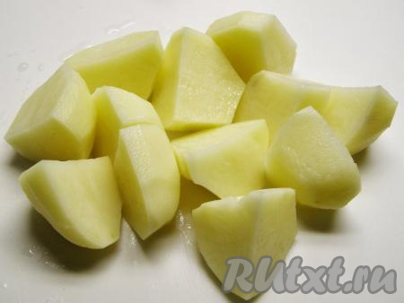 Картофель моем и очищаем от кожицы. Крупные клубни разрезаем на 2 или 4 части и кладём на некоторое время в холодную воду.