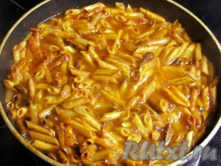 Вливаем горячую кипячёную воду, ещё раз перемешиваем. Уменьшаем огонь до минимального, накрываем сковородку крышкой и готовим жареные макароны с томатной пастой минут 10 (до мягкости макарон, они должны полностью приготовиться), периодически перемешивая. Если в процессе приготовления вода впитается, а макароны останутся твёрдыми, можно долить ещё, примерно, 200-250 мл горячей воды.