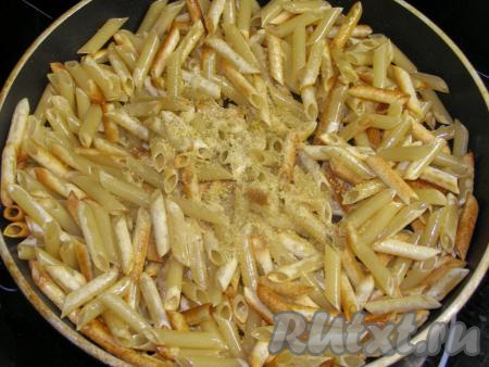 Обжариваем макароны на среднем огне, постоянно помешивая, минут 5-7 (в зависимости от плиты и толщины сковороды). На макаронах должна образоваться золотисто-коричневая корочка. Затем добавляем 1 чайную ложку универсальной приправы (или размельчённый бульонный кубик), солим.