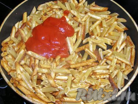 Добавляем в сковородку к макаронам томатную пасту и сразу перемешиваем.