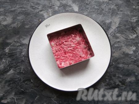 Выкладывать салат на тарелку с помощью кулинарной формочки (или кольца). Выложить половину салата, разровнять.