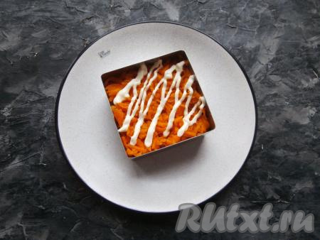 Морковку натереть на крупной тёрке и половину выложить в формочку ровным слоем, смазать немного майонезом.