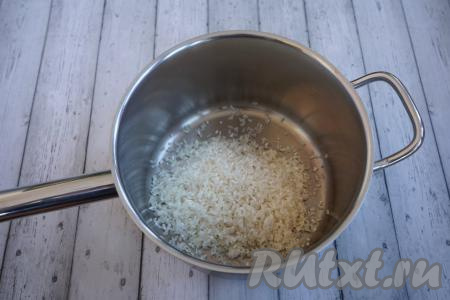 Теперь капустные листья отставляем в сторону и начинаем заниматься начинкой. Тщательно промываем 200 грамм риса. Я обычно беру «Краснодарский», но для голубцов существенной разницы нет, поэтому и любой длиннозёрный отлично подойдёт. Перекладываем промытый под проточной водой рис в сотейник и заливаем 400 мл воды, ставим на огонь, даём воде закипеть и отвариваем рис до полуготовности (примерно, 5-7 минут).