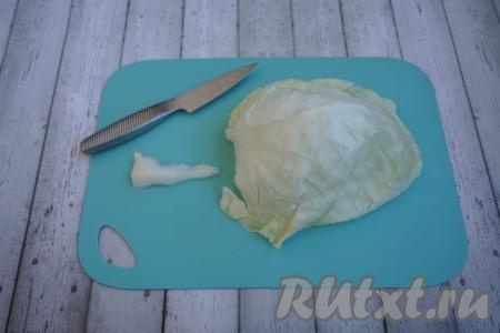 Даём капустным листьям немного остыть. Затем с каждого листа срезаем плотные, твёрдые части, расположенные по центру листа (как на фото).