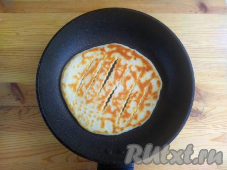 Затем лепёшку перевернуть на другую сторону и жарить до золотистости с другой стороны (на это потребуется около 1,5 минут). Готовую лепёшку переложить на тарелку. Аналогично пожарить оставшиеся 3 лепёшки, складывая их горочкой на тарелку.