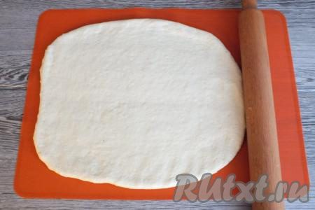 Через 30 минут тесто снова увеличится в объёме и будет готово к разделке. Раскатайте тесто на присыпанной мукой поверхности с помощью скалки в прямоугольной пласт толщиной 0,3 см. Важно, чтобы середина и края пласта были одинаковой толщины.